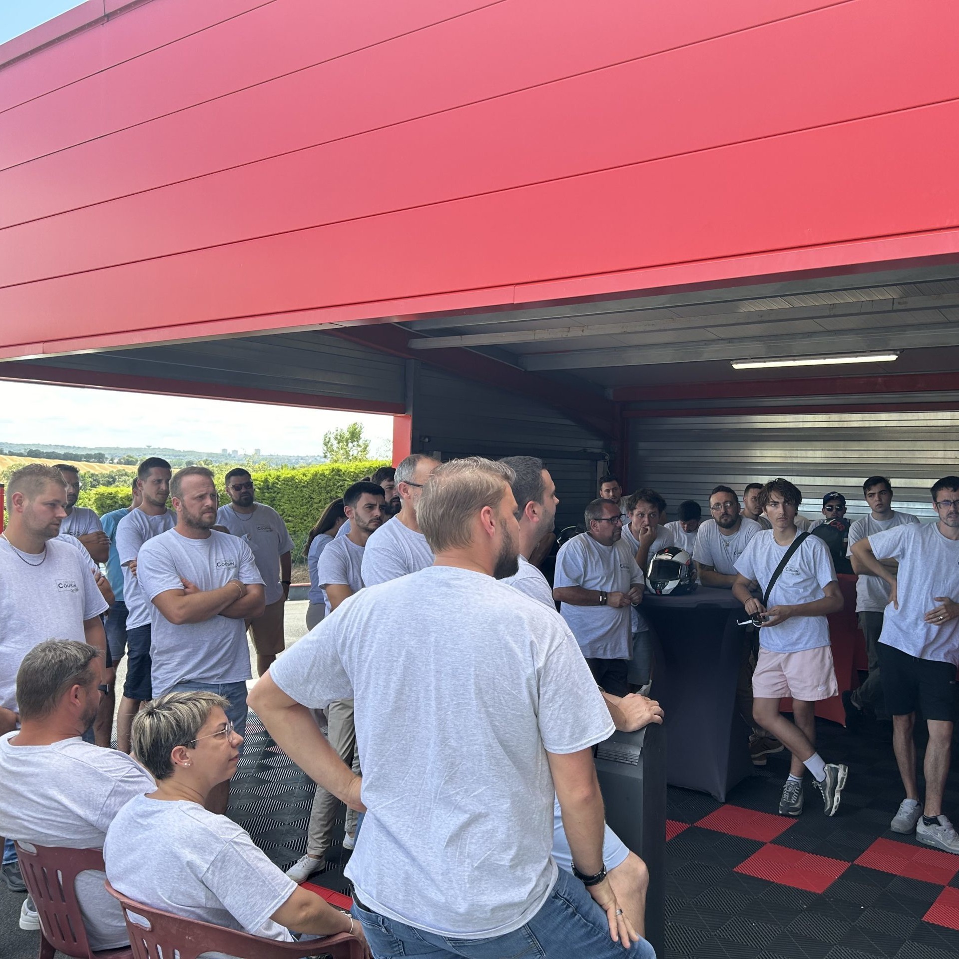 Groupe de personnes en r&eacute;union sous un abri rouge.