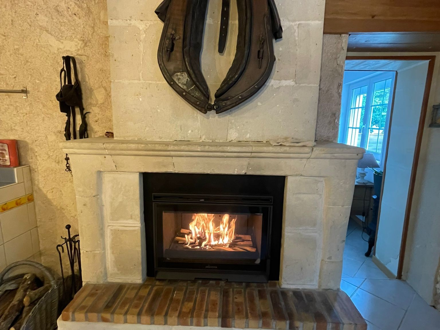 Cheminée rustique avec feu et sculpture murale.